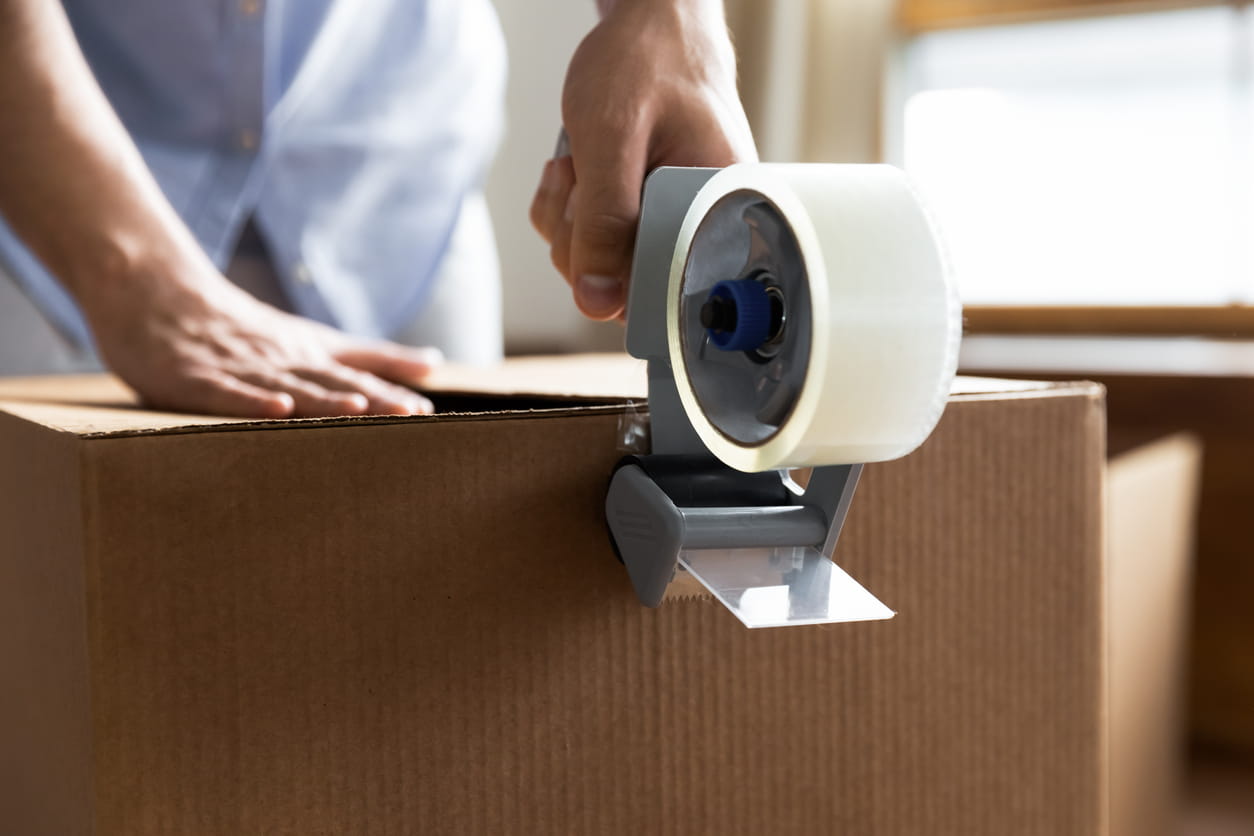 Home Moving Essentials Checklist | MD Movers taping box in preparation for moving